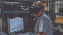 person using black VR Headset in front of computer