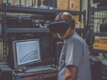 person using black VR Headset in front of computer