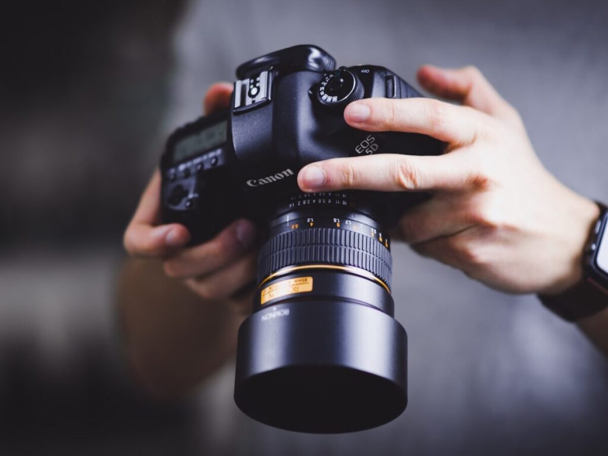 person holding Canon DSLR camera