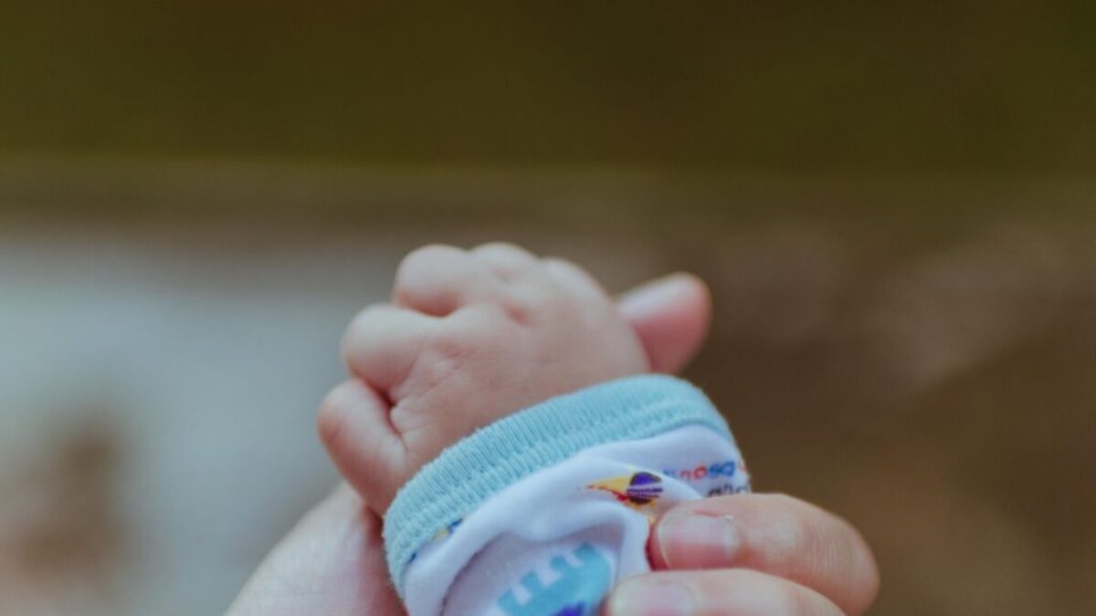 person holding baby's hand