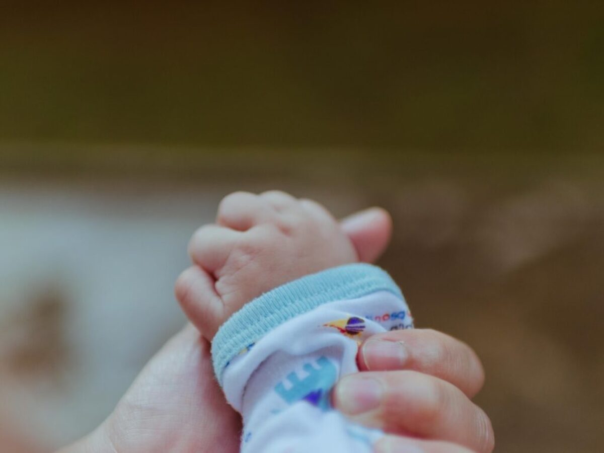 person holding baby's hand