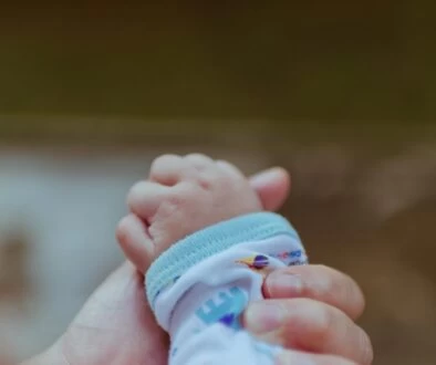 person holding baby's hand