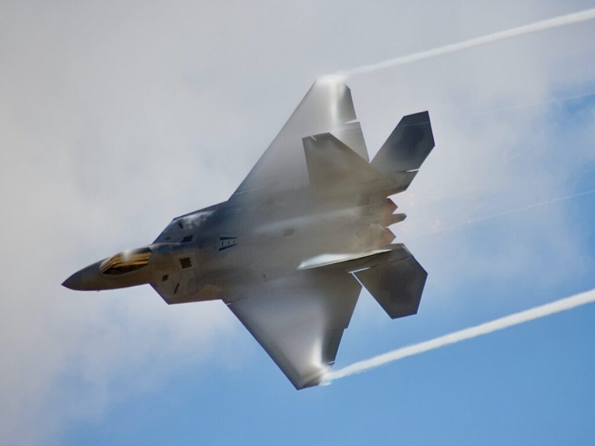 black jet plane in mid air during daytime