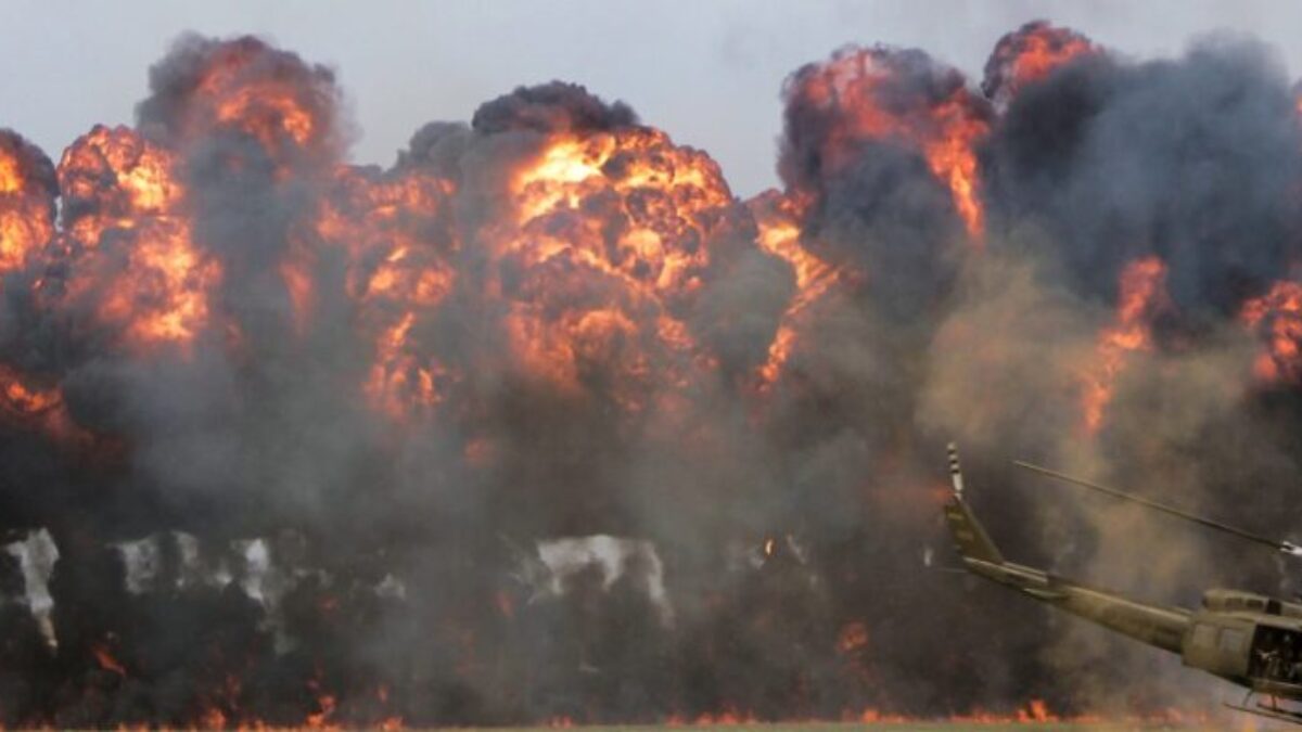 green helicopter near big fire