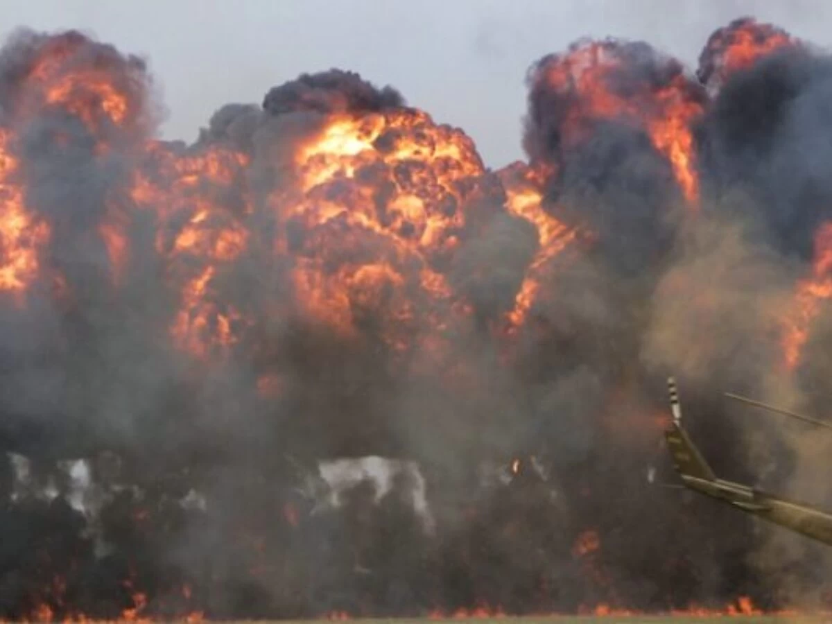 green helicopter near big fire