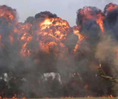 green helicopter near big fire
