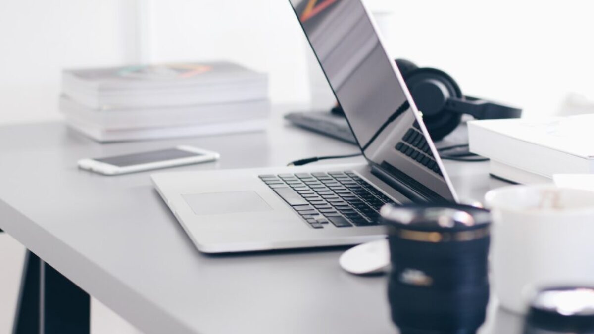 silver MacBook Pro on white table