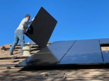 man in white dress shirt and blue denim jeans sitting on white and black solar panel