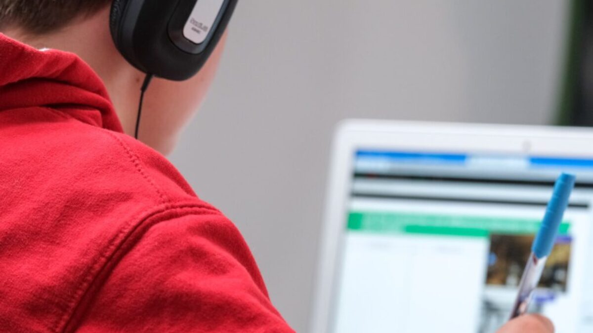person in red shirt wearing black and gray headphones