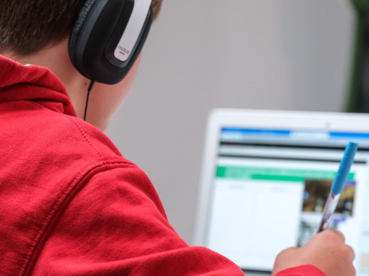 person in red shirt wearing black and gray headphones