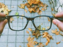 person holding black-framed eyeglasses