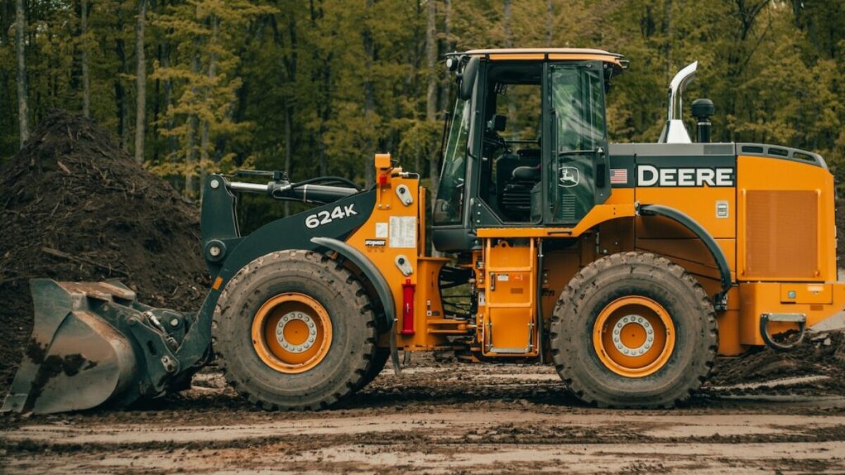 a tractor is parked in the dirt near a pile of dirt