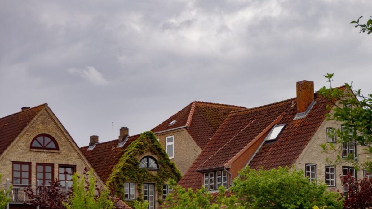 brown and white concrete house under white clouds during daytime