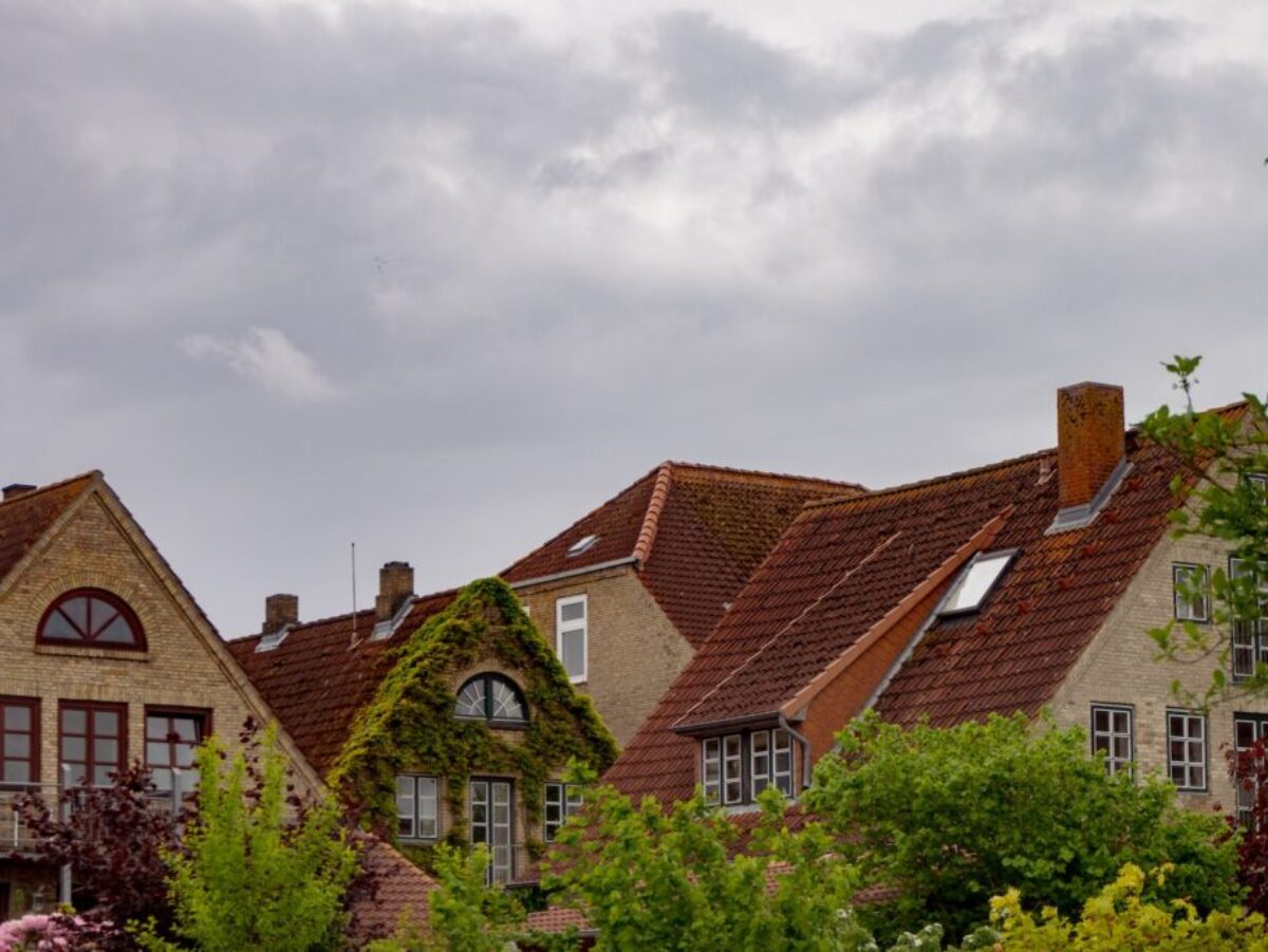 brown and white concrete house under white clouds during daytime