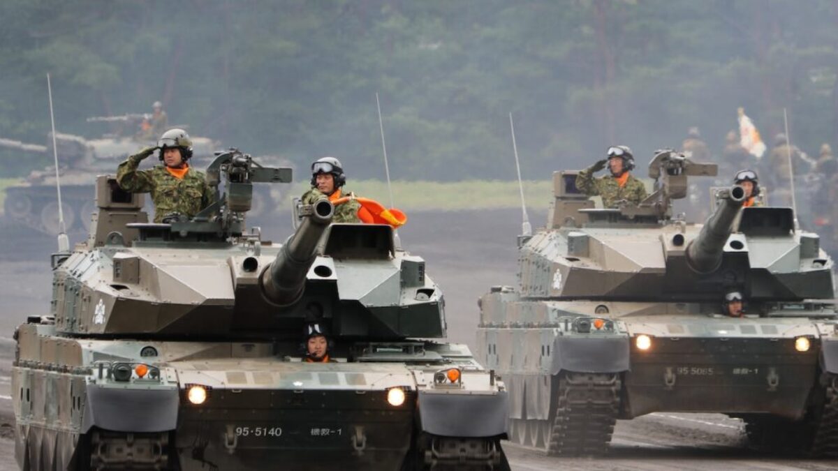 a group of military tanks driving down a road