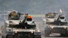 a group of military tanks driving down a road