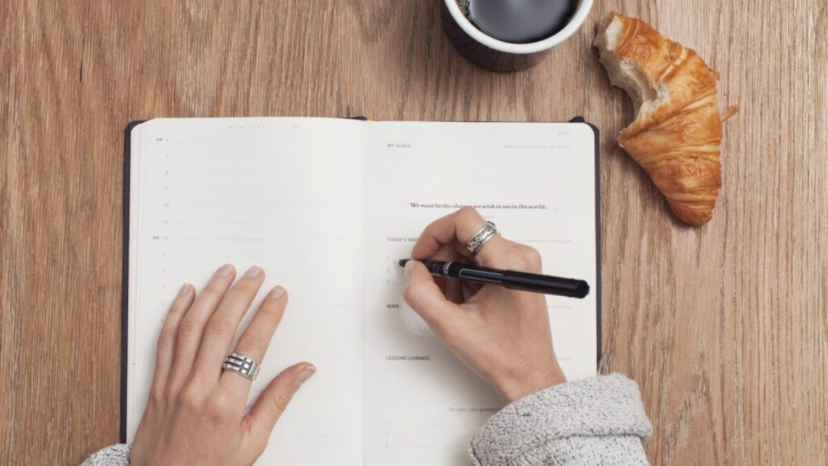 person writing on a book