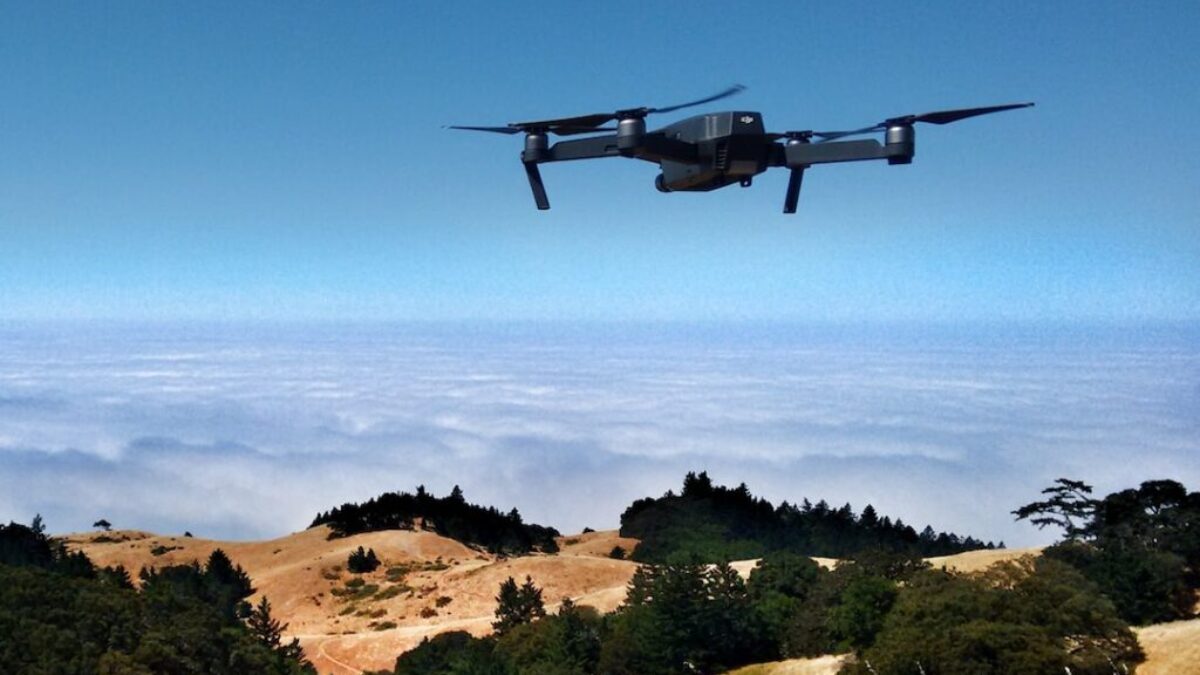 black drone on air over cloudy sky at daytime
