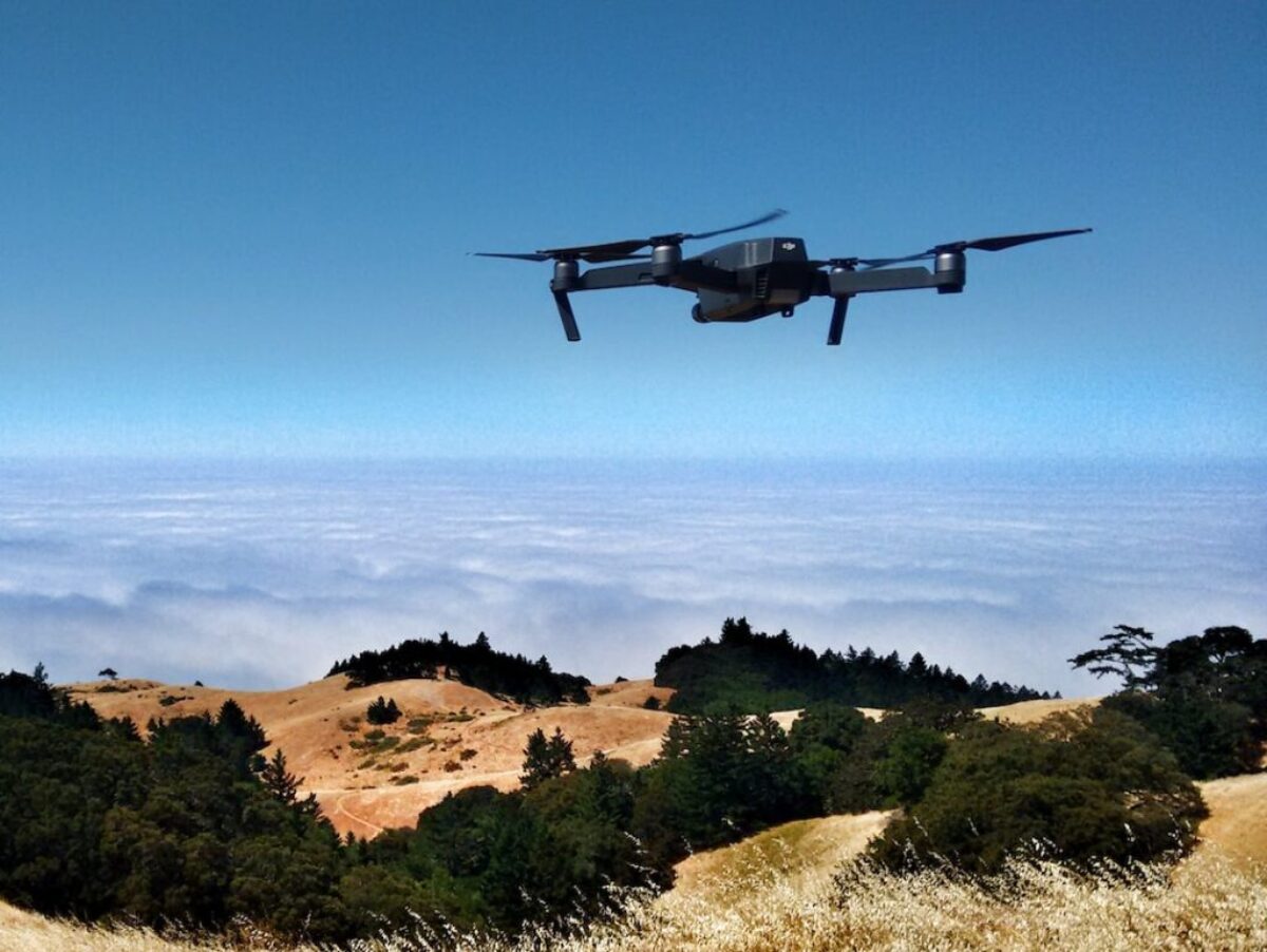 black drone on air over cloudy sky at daytime