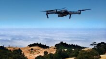 black drone on air over cloudy sky at daytime