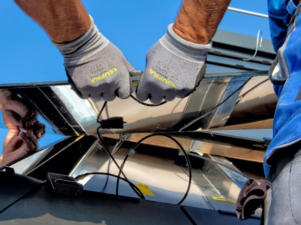 two men carrying a metal sheet