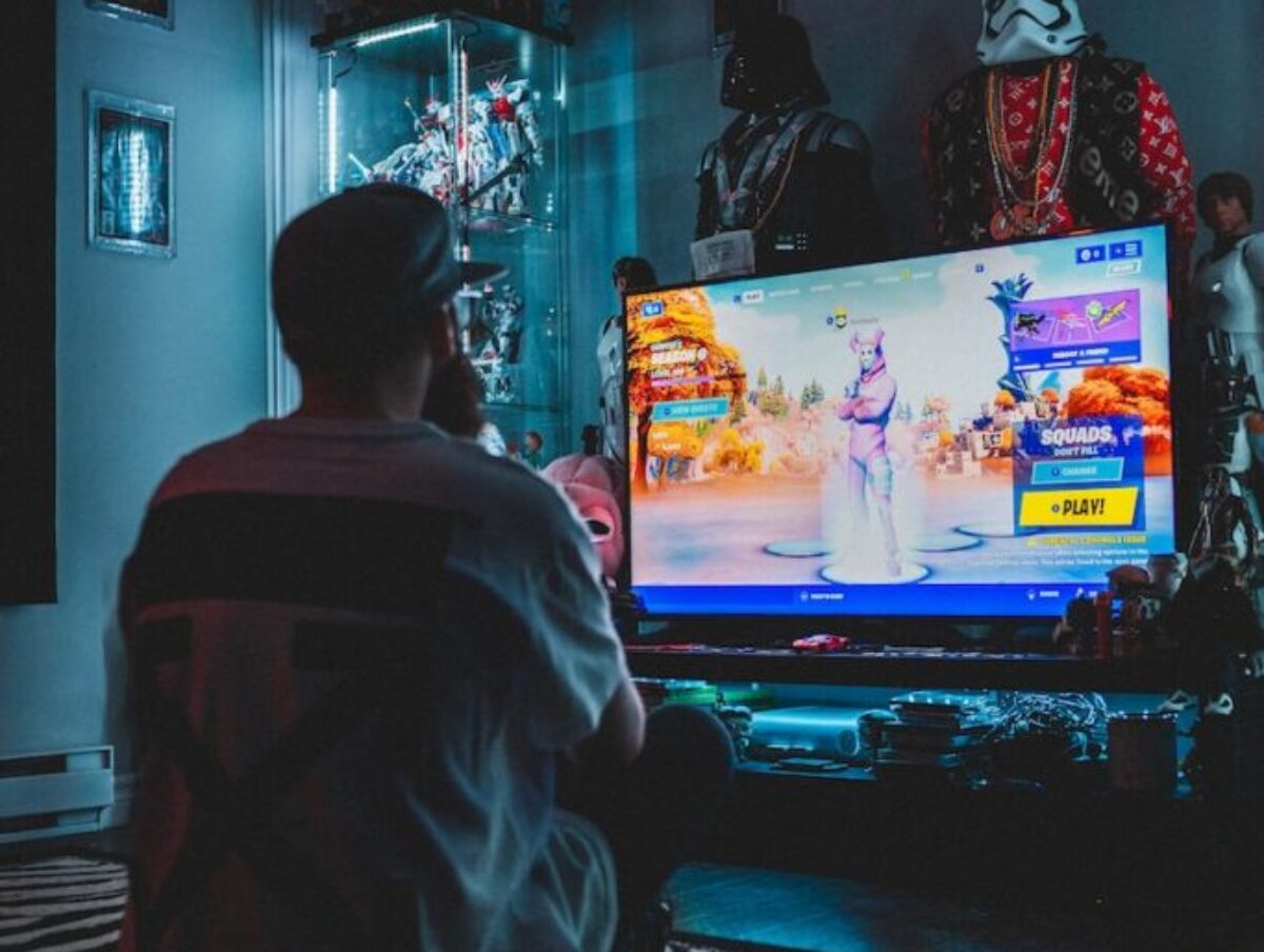 man in red shirt watching tv