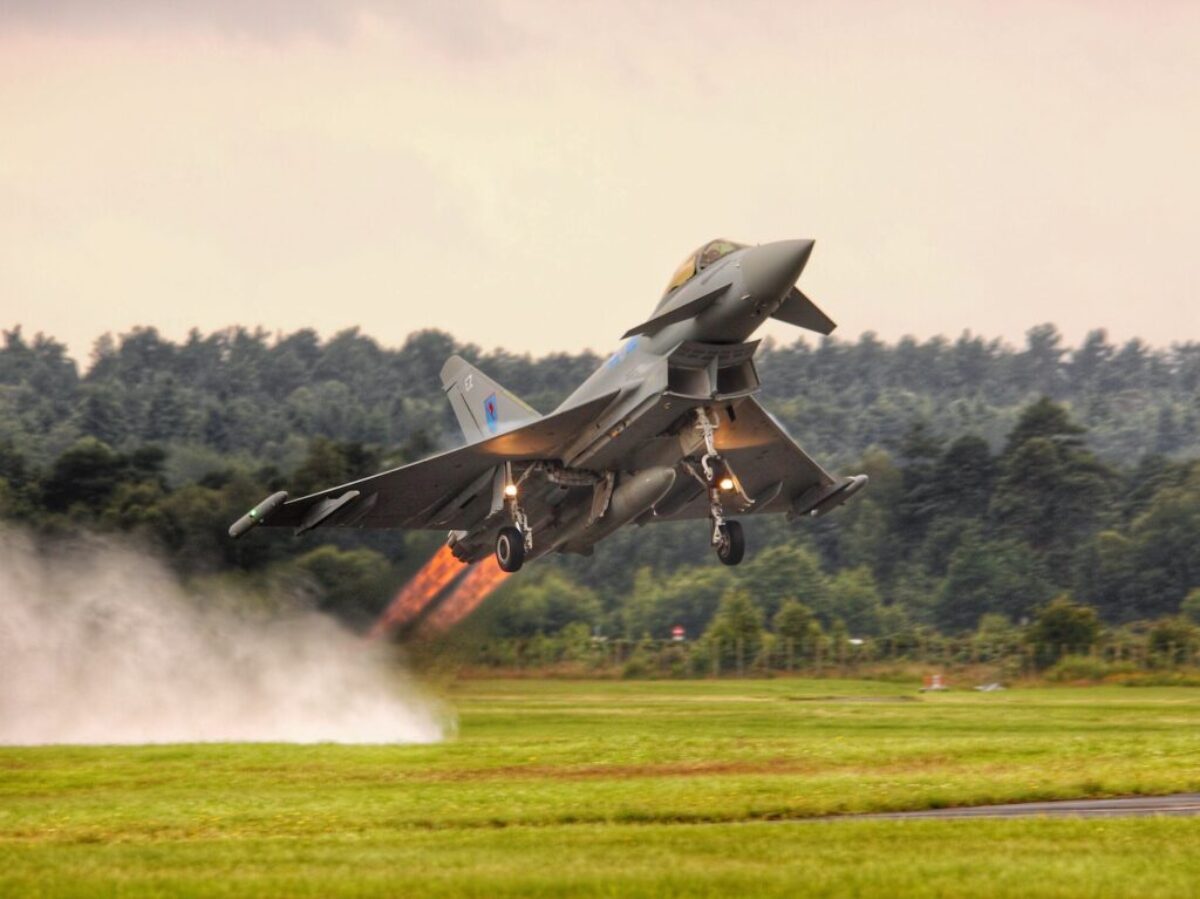 black jet plane on green grass field during daytime