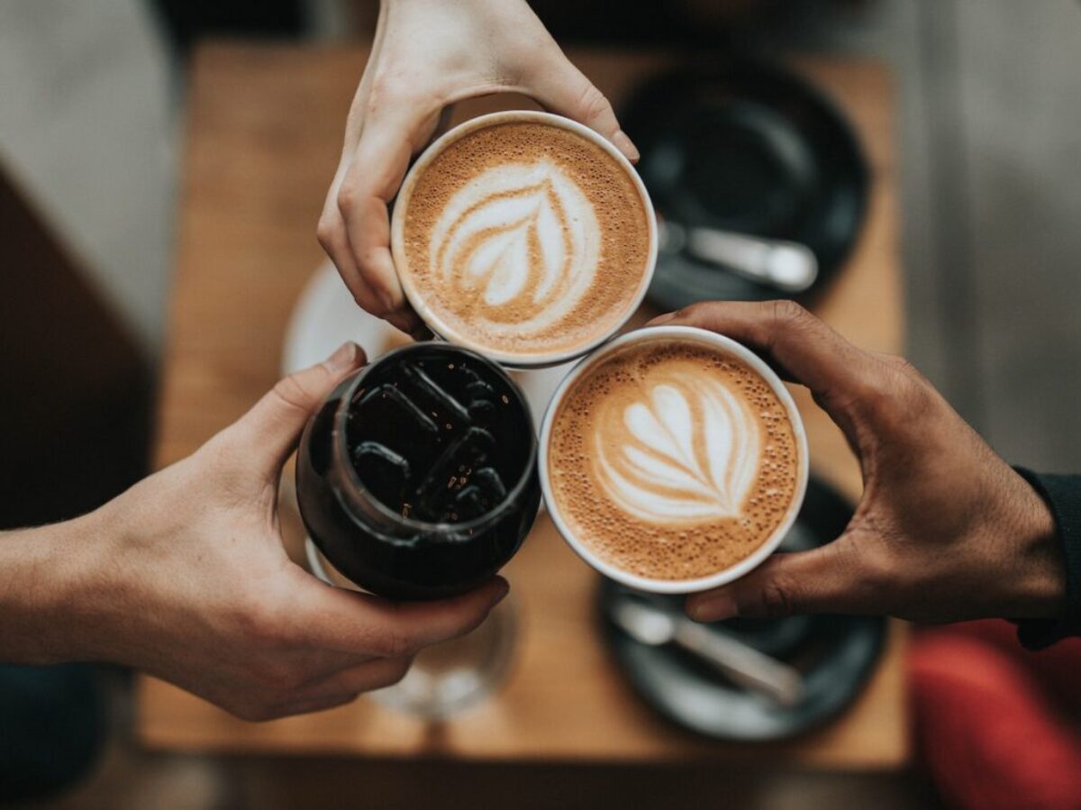 three person holding beverage cups