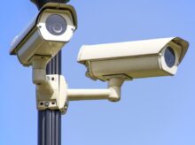 White 2 Cctv Camera Mounted on Black Post Under Clear Blue Sky