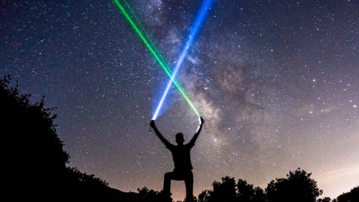 man holding green and blue flashlights
