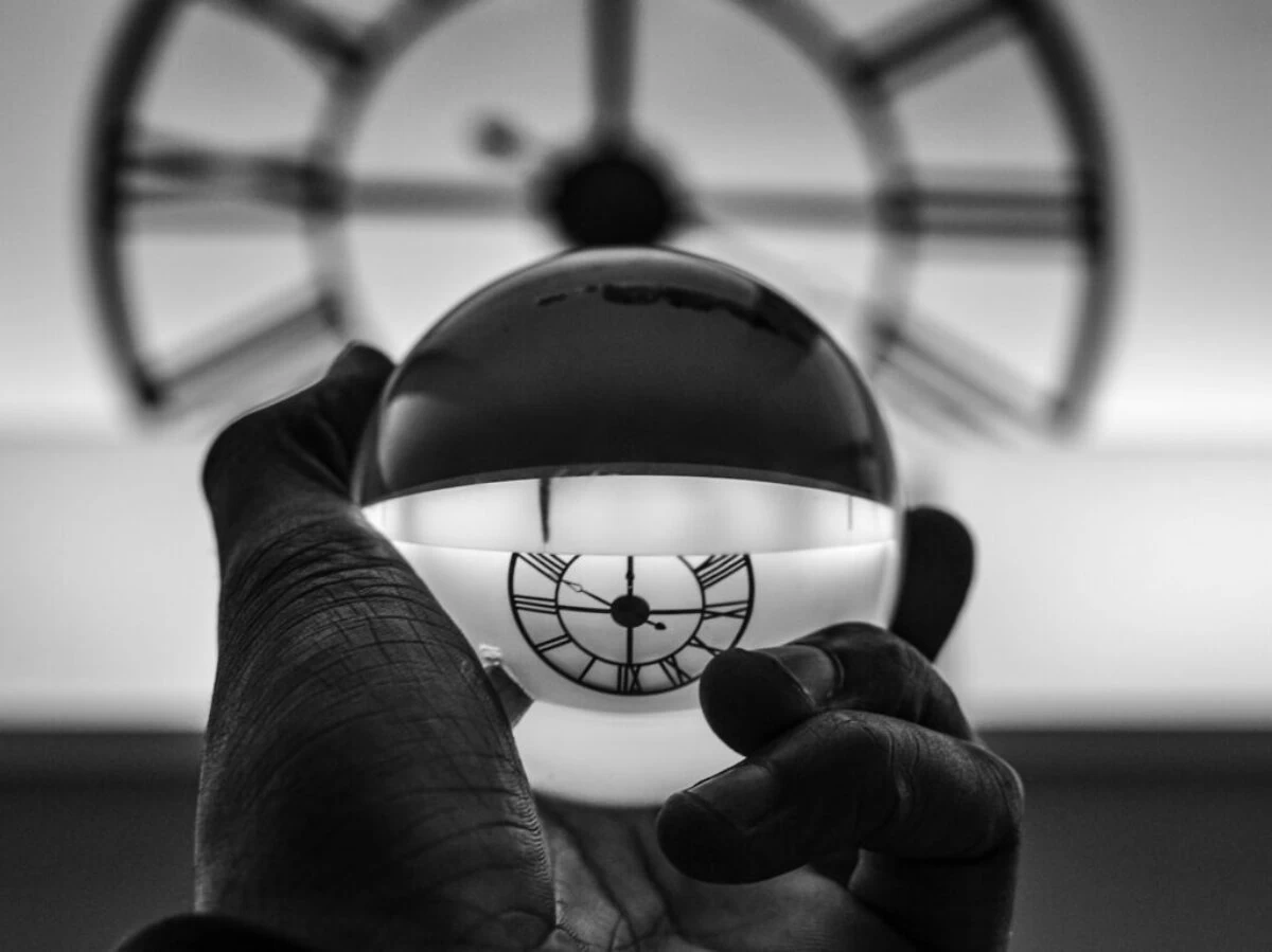 grayscale photography of person holding glass ball