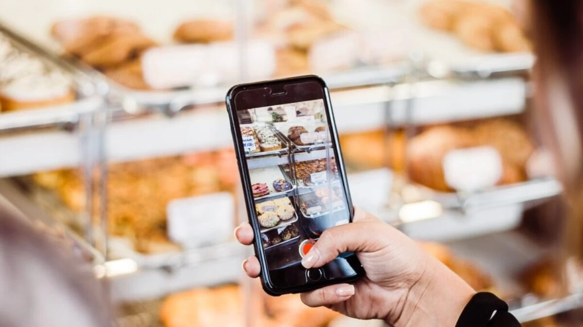 woman taking photo food display