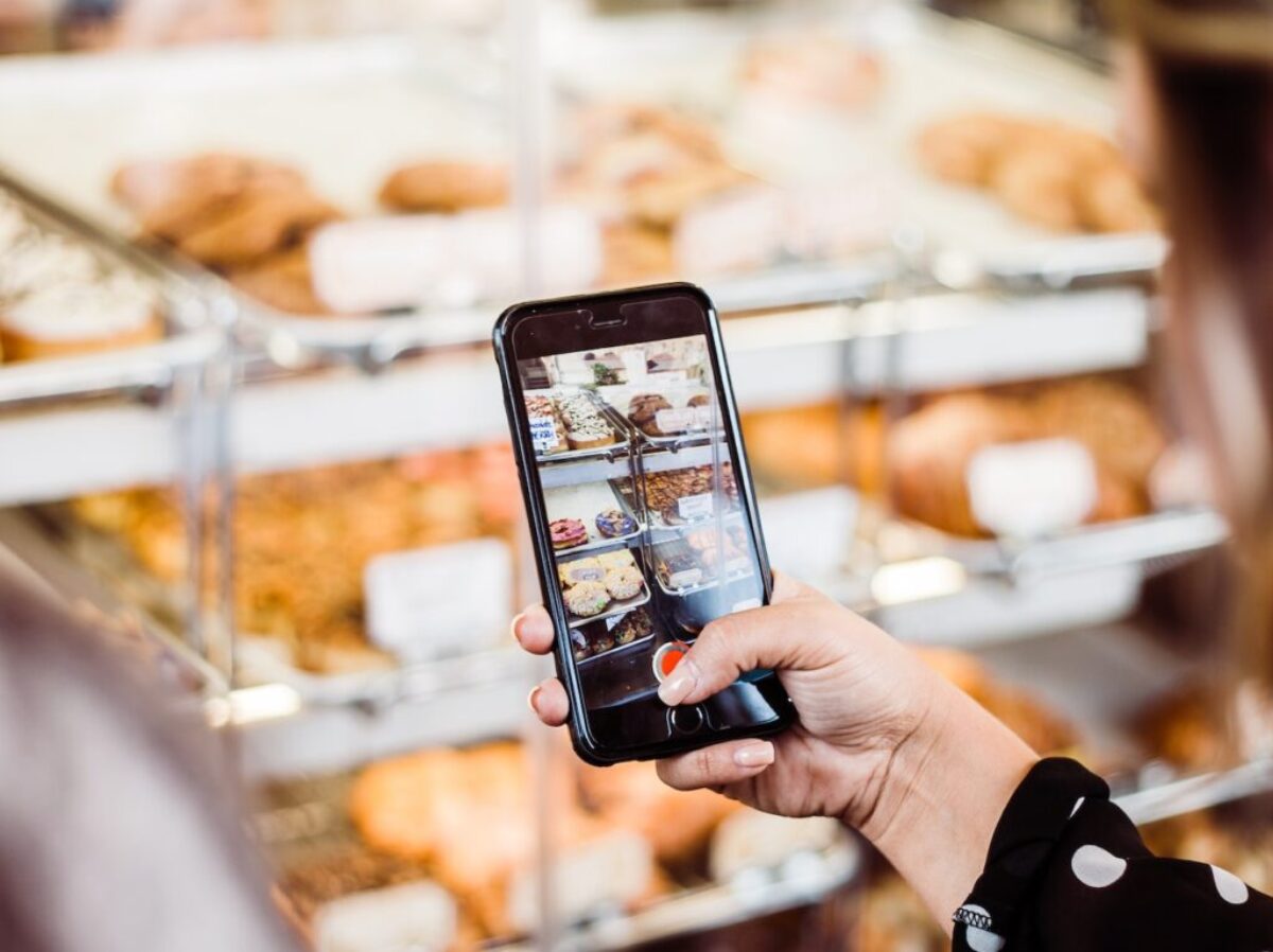 woman taking photo food display