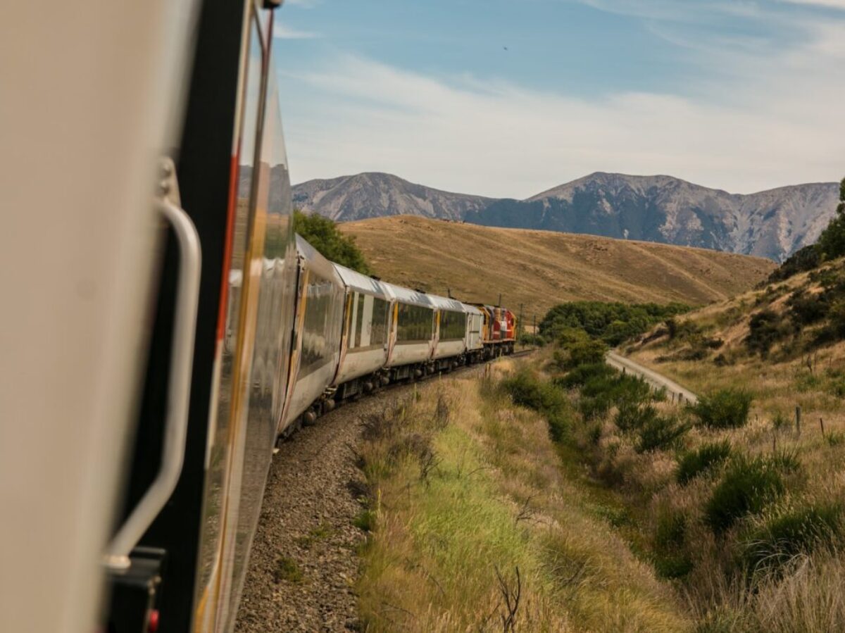 white train with the distance of mountain during daytime