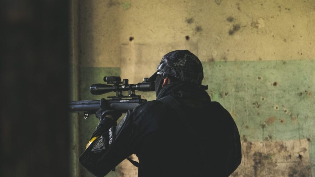 man in black jacket holding rifle
