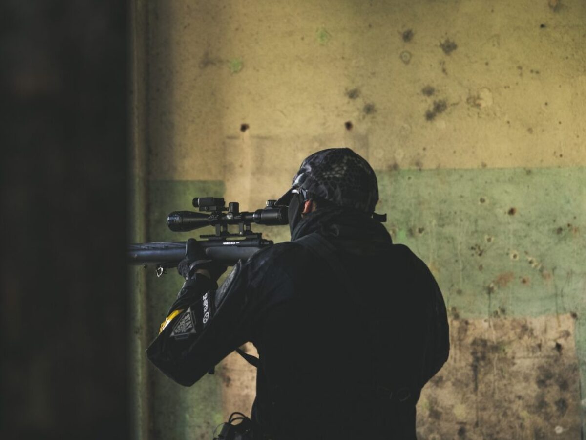 man in black jacket holding rifle