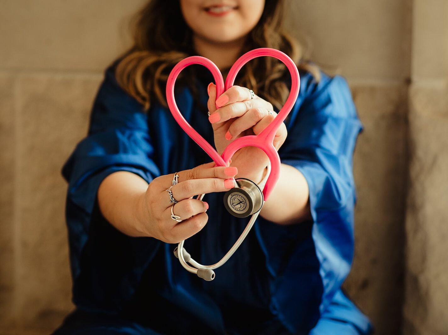 girl in blue jacket holding red and silver ring