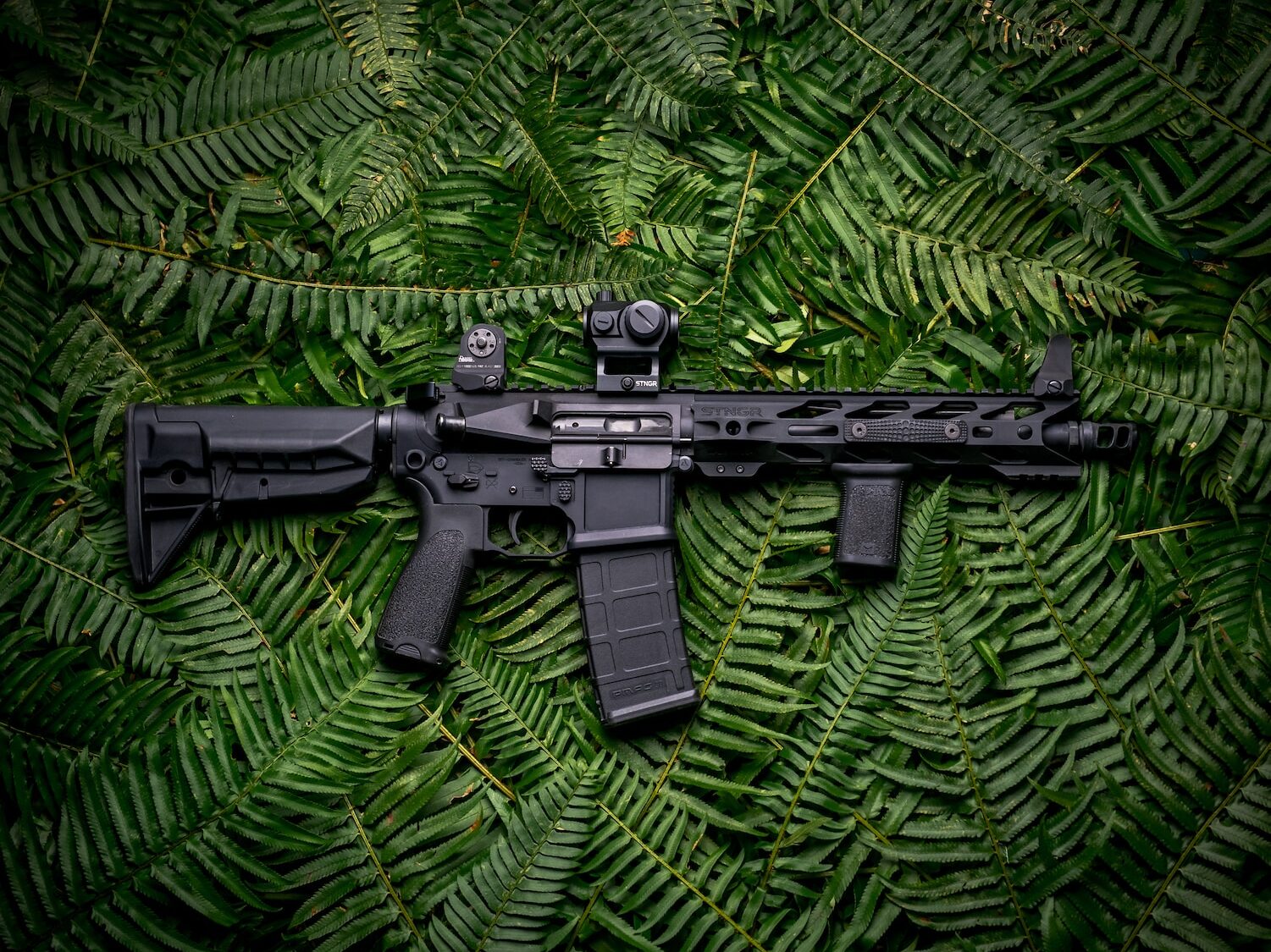 black rifle on green textile