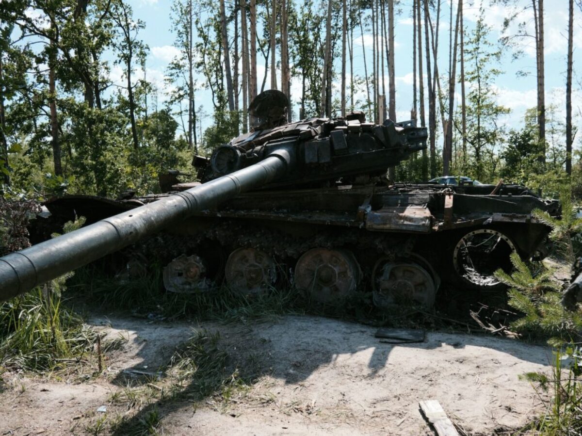 an old tank sitting in the middle of a forest