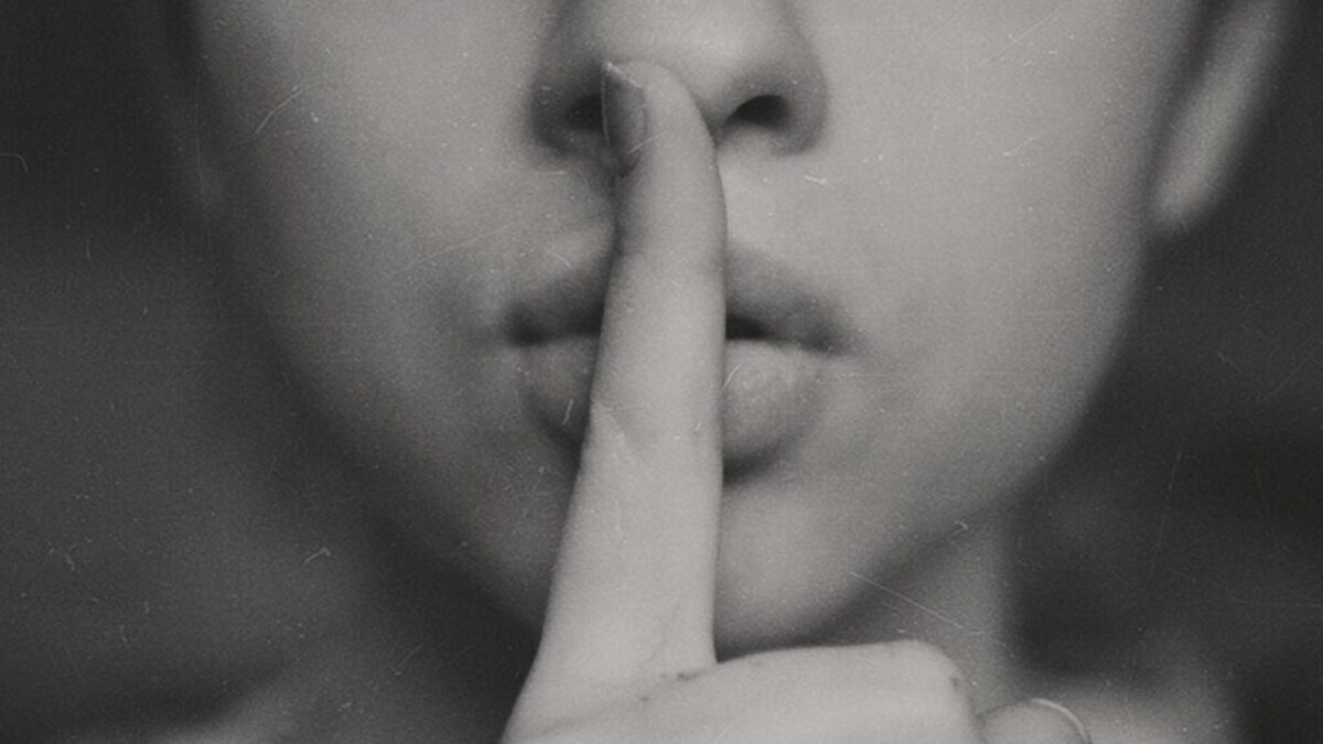 grayscale photo of woman doing silent hand sign