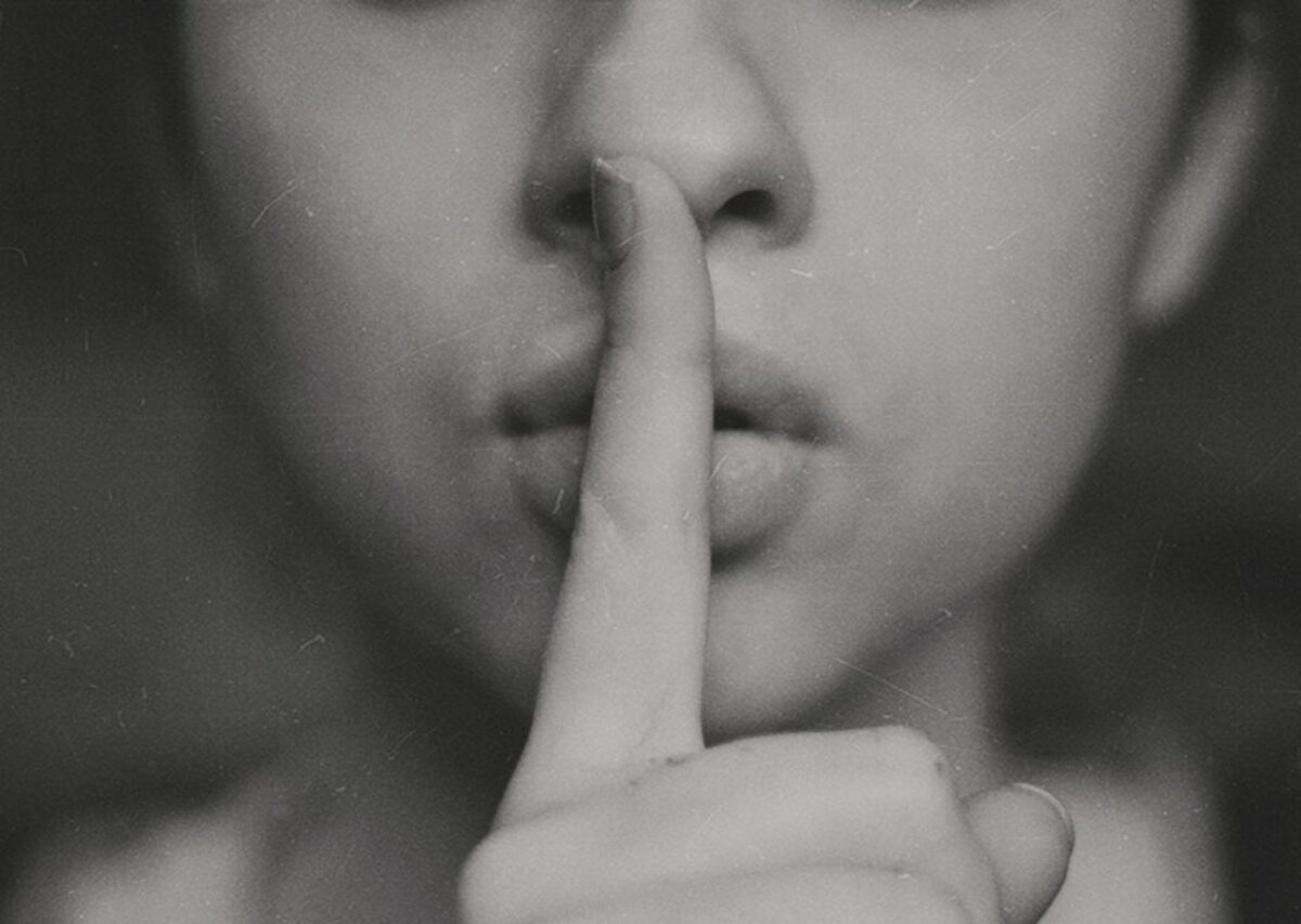 grayscale photo of woman doing silent hand sign