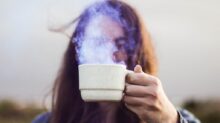 selective focus photo of man holding white ceramic coffee cup