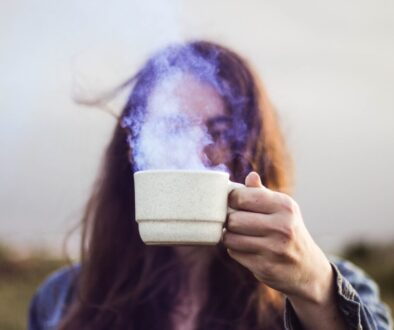 selective focus photo of man holding white ceramic coffee cup