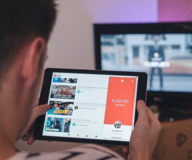 man browsing tablet sitting in front of TV