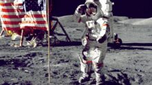 astronaut standing on moon beside U.S.A. flag