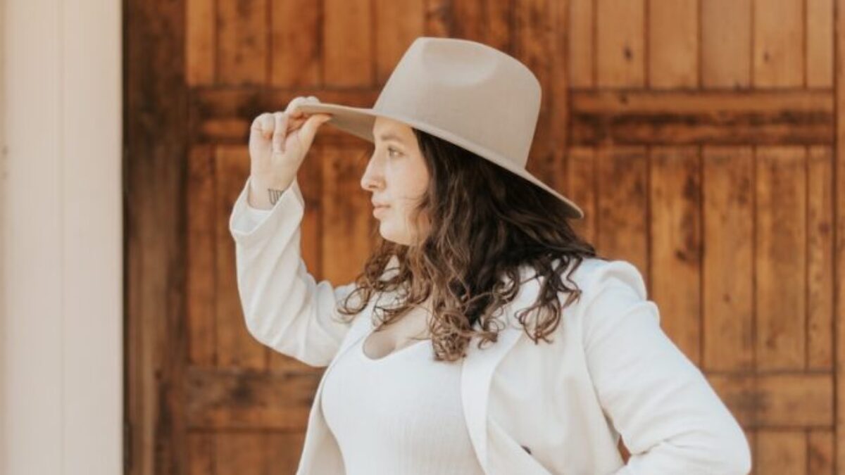 woman in white long sleeve shirt and blue denim daisy dukes wearing white cowboy hat