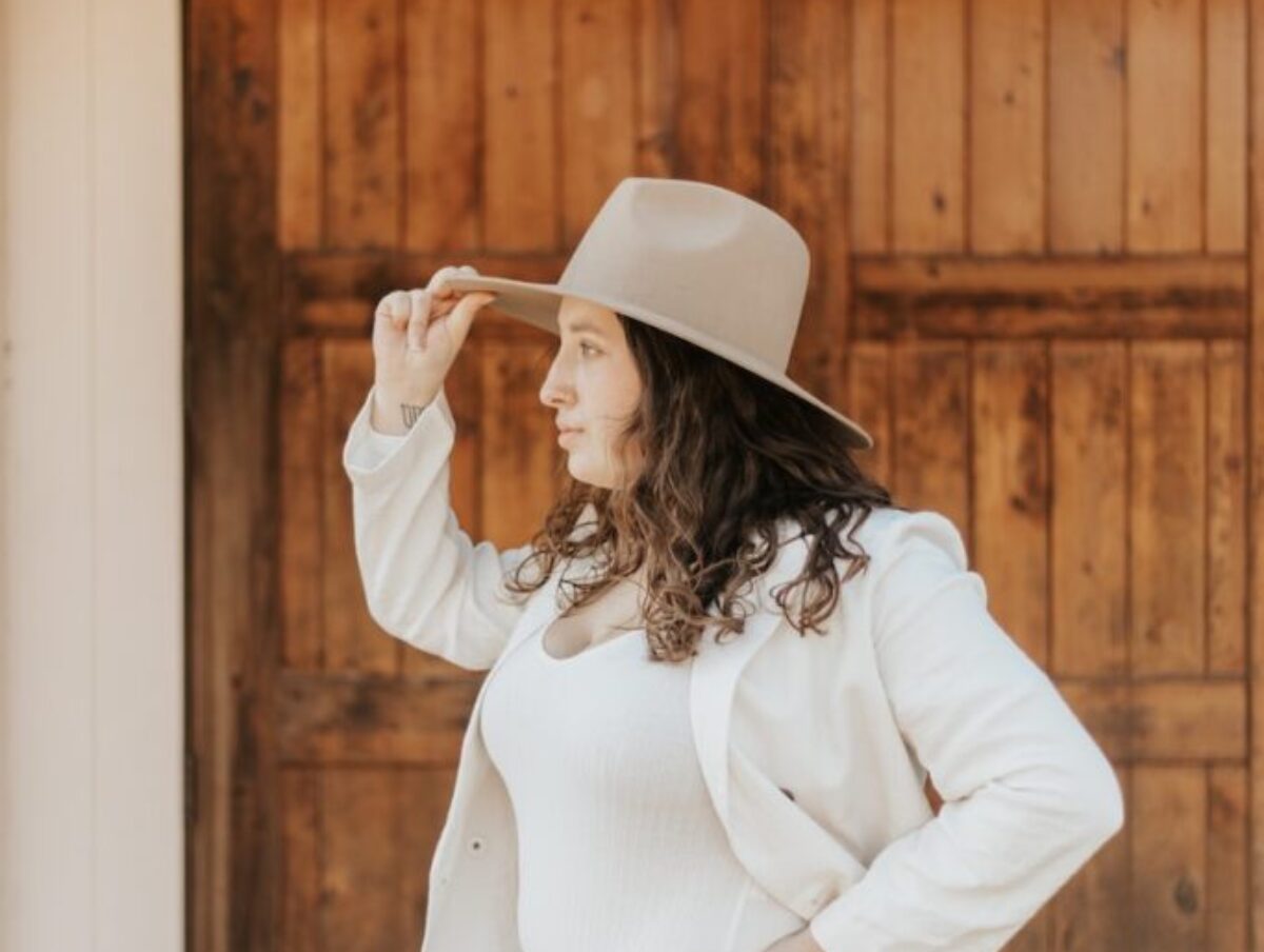 woman in white long sleeve shirt and blue denim daisy dukes wearing white cowboy hat