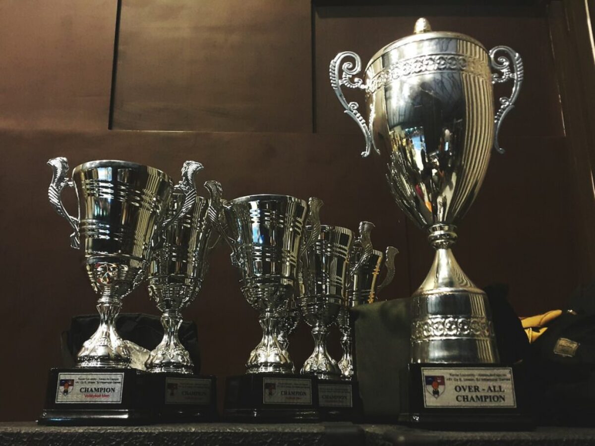 several silver and gold trophies on wooden surface