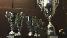several silver and gold trophies on wooden surface