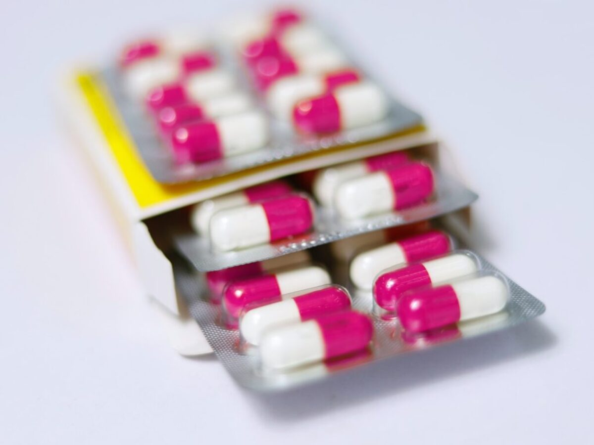 white and red medication pill on yellow box